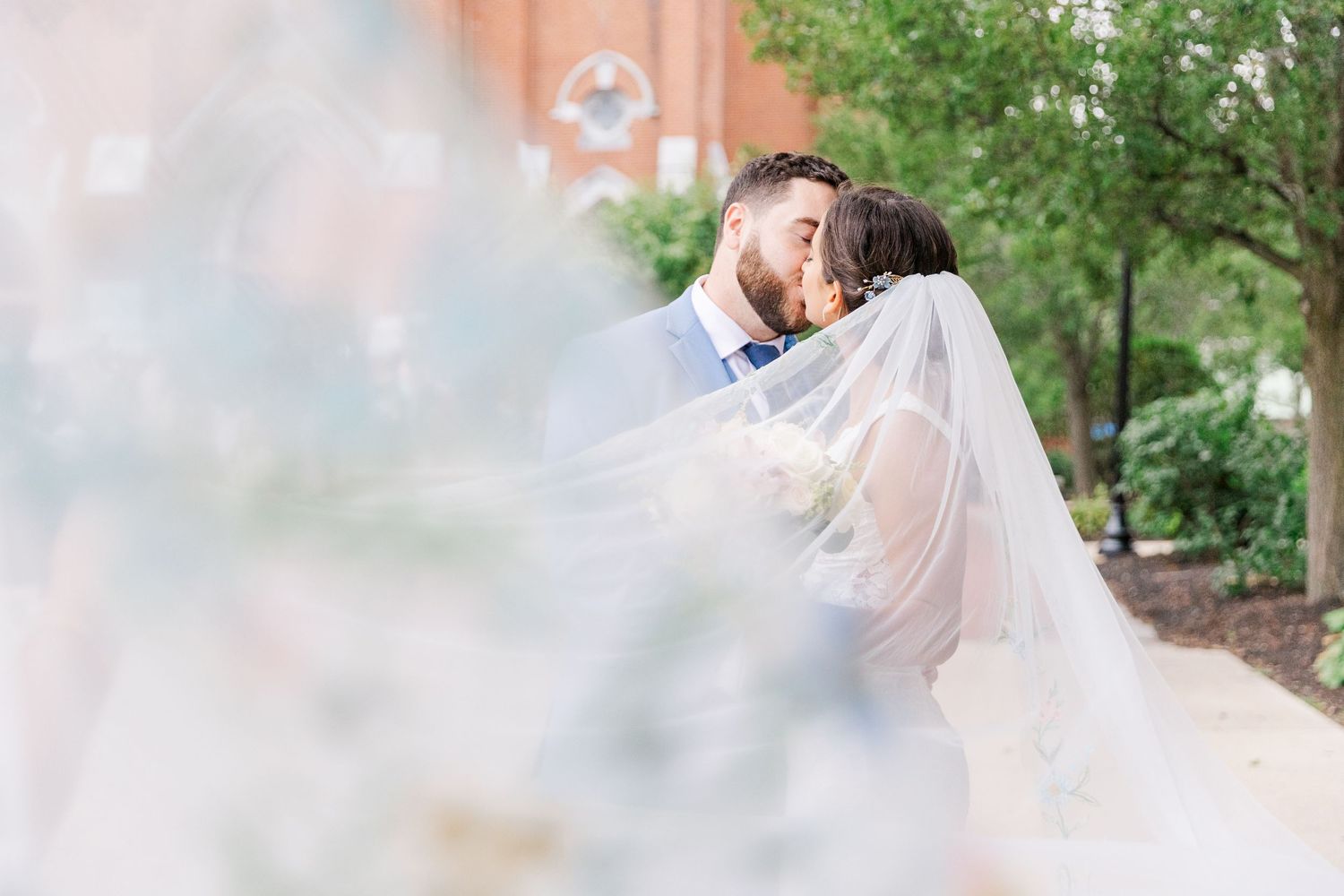 Romantic wedding portrait through delicate veil with soft dreamy effect.