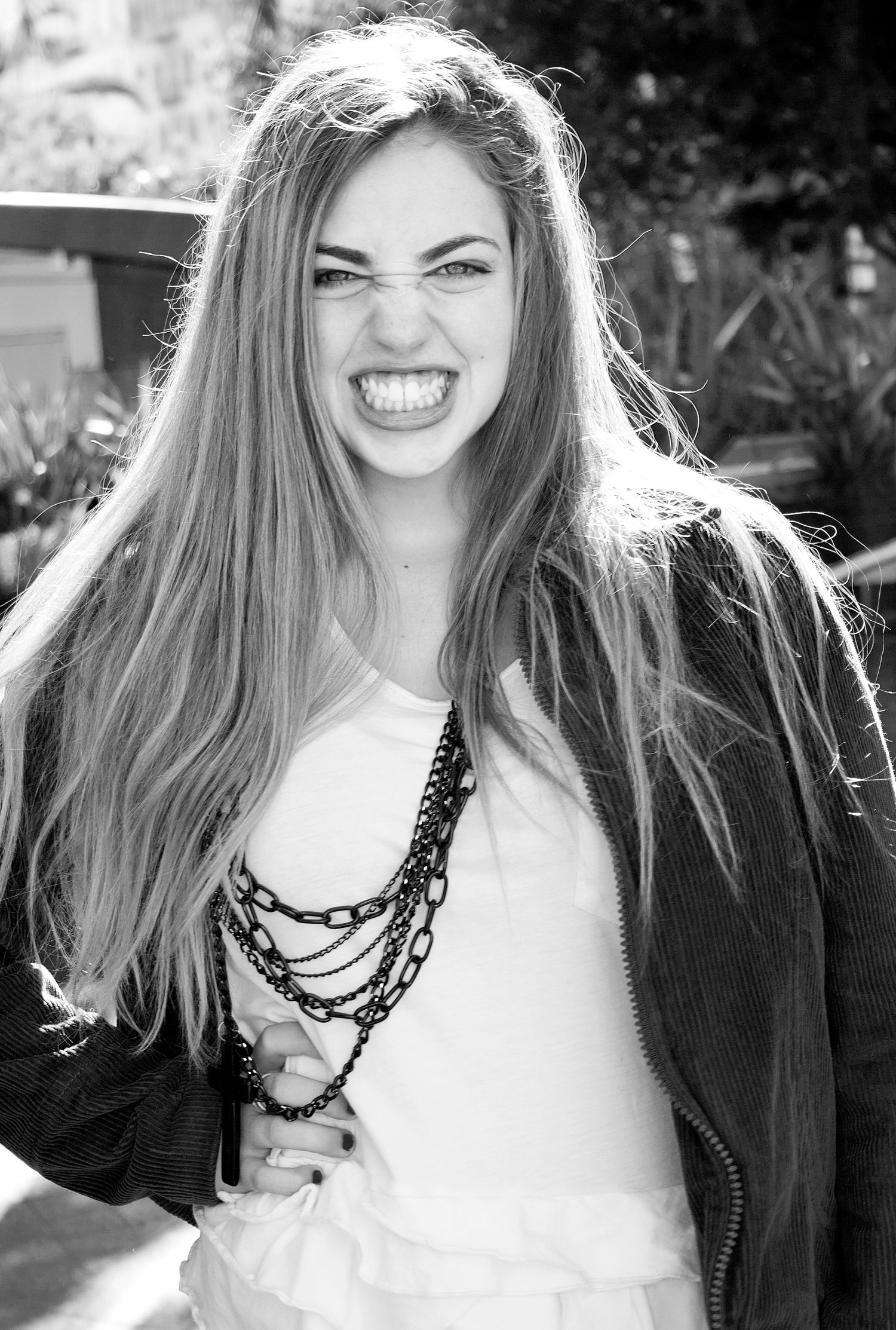 Black and white portrait featuring expressive joy and layered necklace accessories.