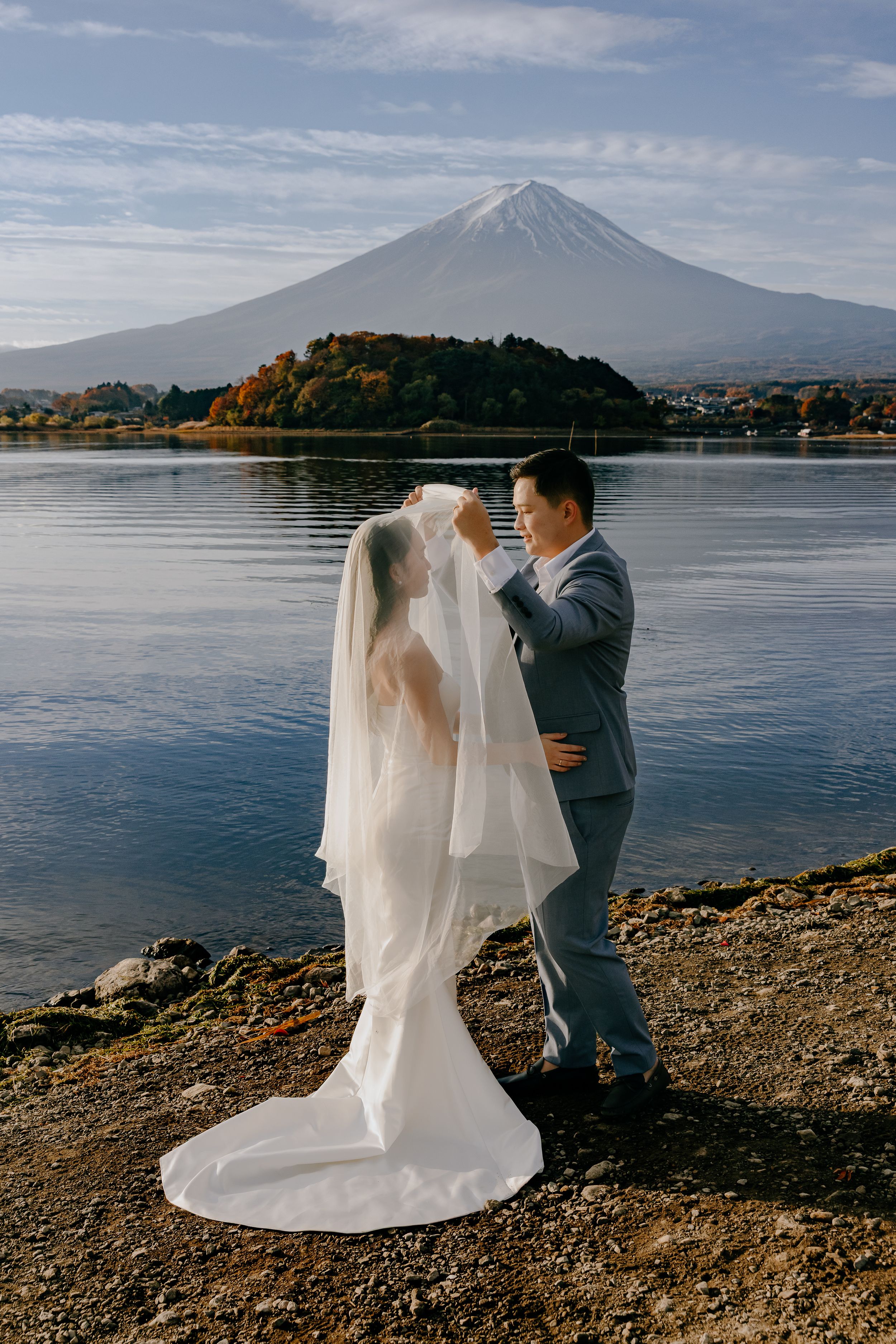 A romantic wedding photoshoot by Lake Kawaguchi with Mount Fuji creating a majestic backdrop in Japan.