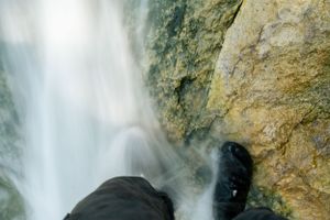 Close-up view of powerful waterfall spray against rocky cliff face.