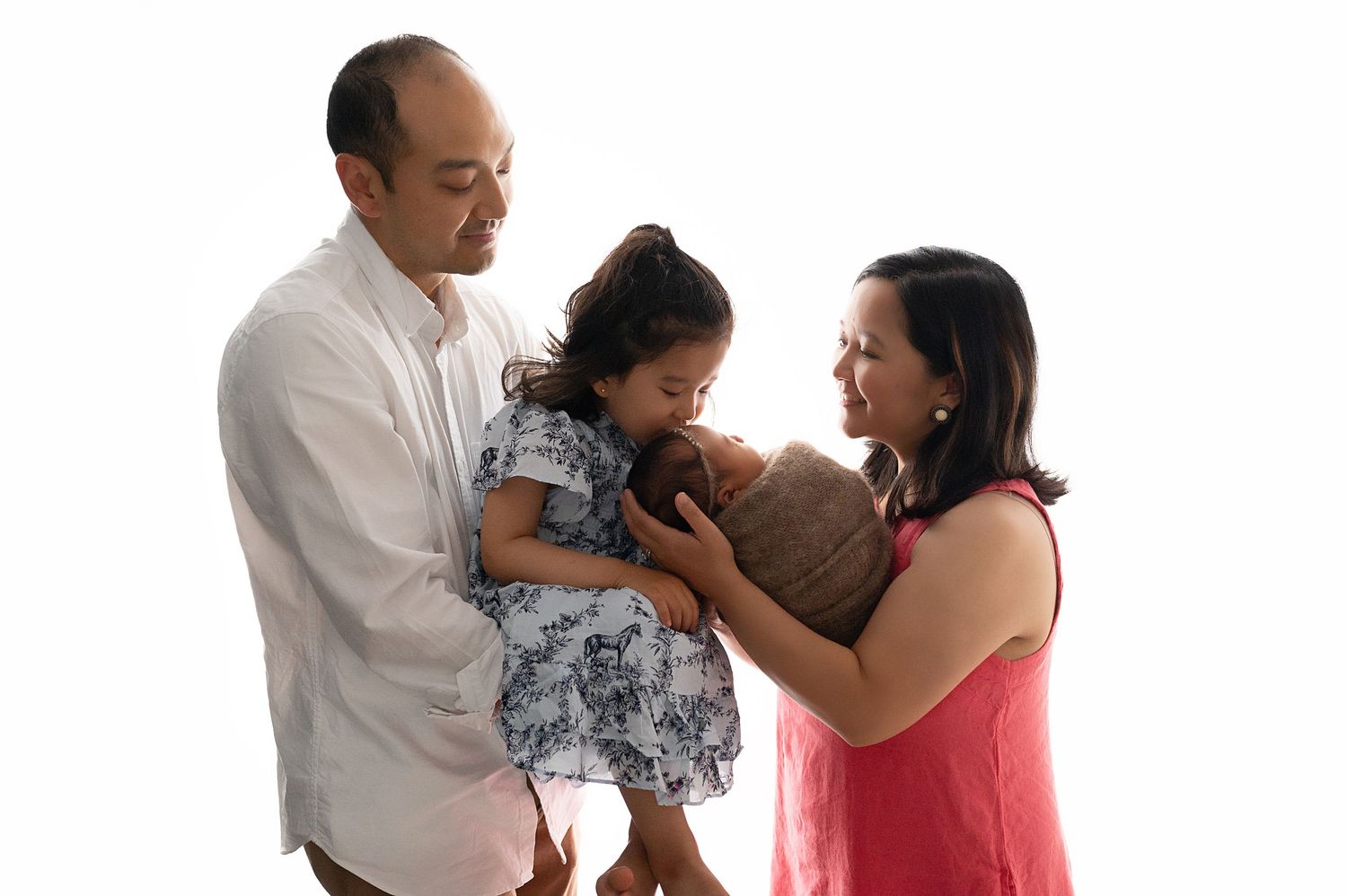 Family of three sharing joyful moment against white background.