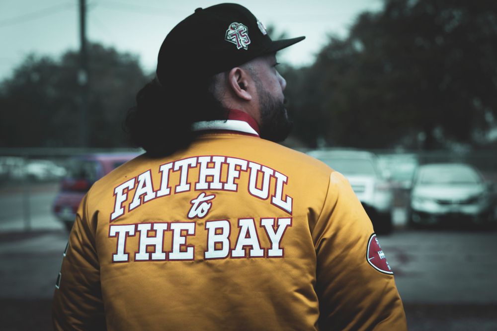 Yellow varsity jacket with 'THE BAY' text visible from behind.