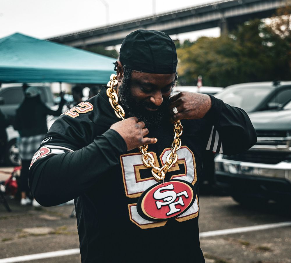 Black hoodies with San Francisco 49ers logos and gold chain accessories.