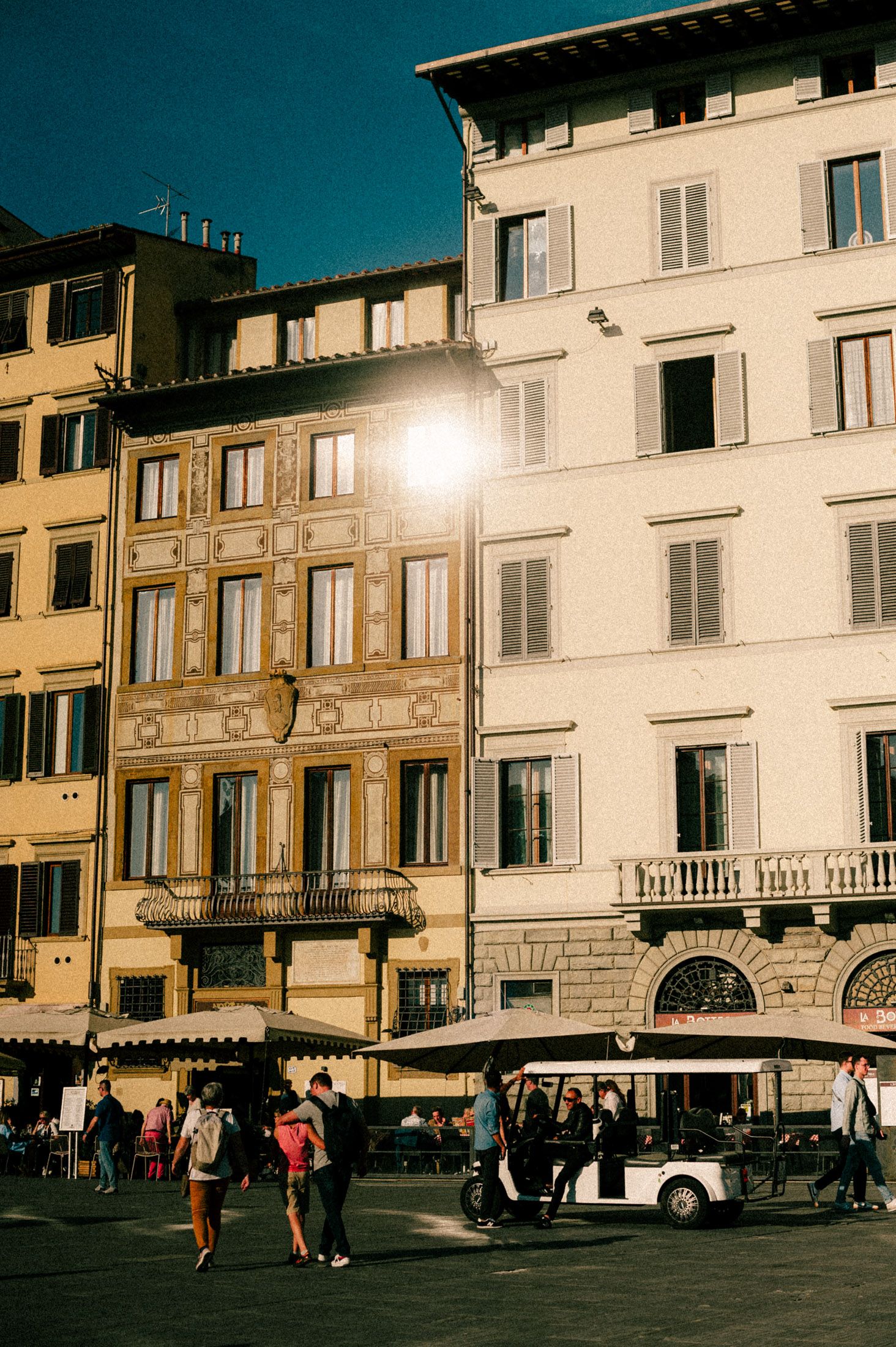 Historic Italian buildings with traditional architecture and shuttered windows in Florence city center at sunset.
