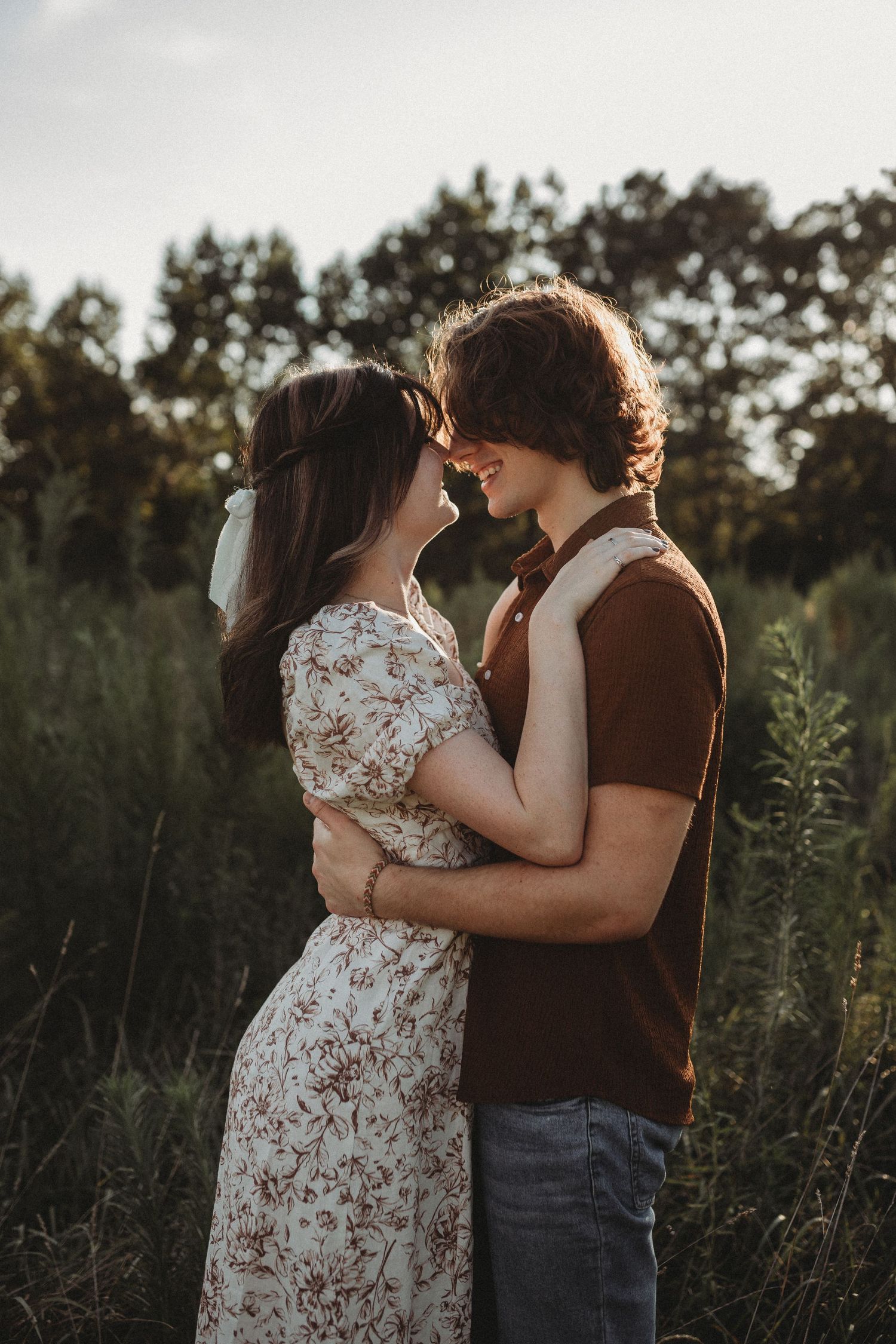 Couple in contrasting outfits shares intimate moment in wildflower field.