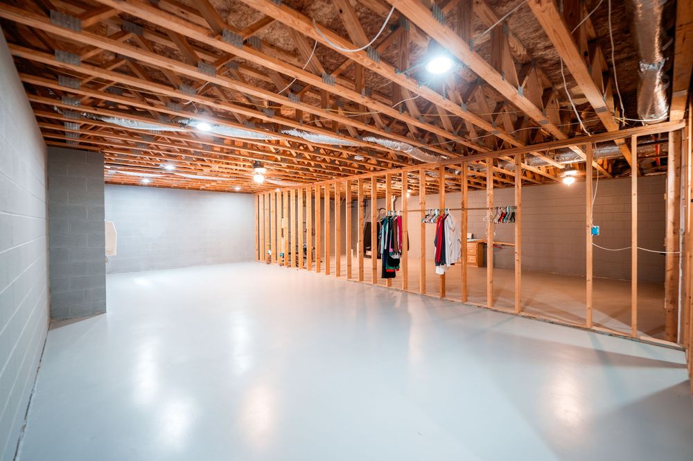 Exposed wooden beams and rafters in an unfinished commercial building interior with bright overhead lighting.