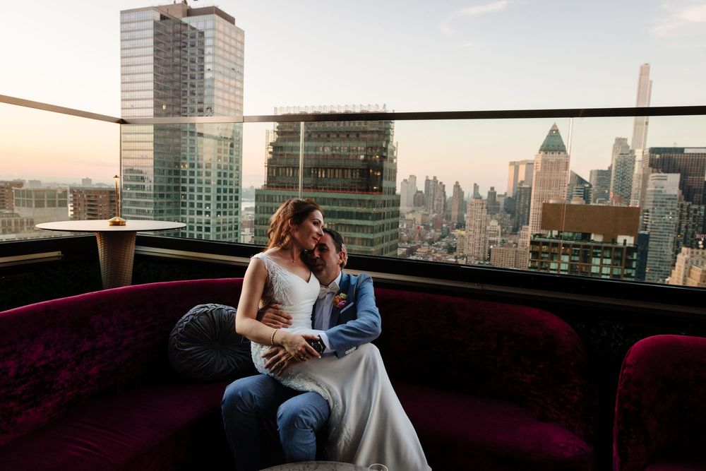 Modern city skyline view from a luxurious lounge area with burgundy seating.