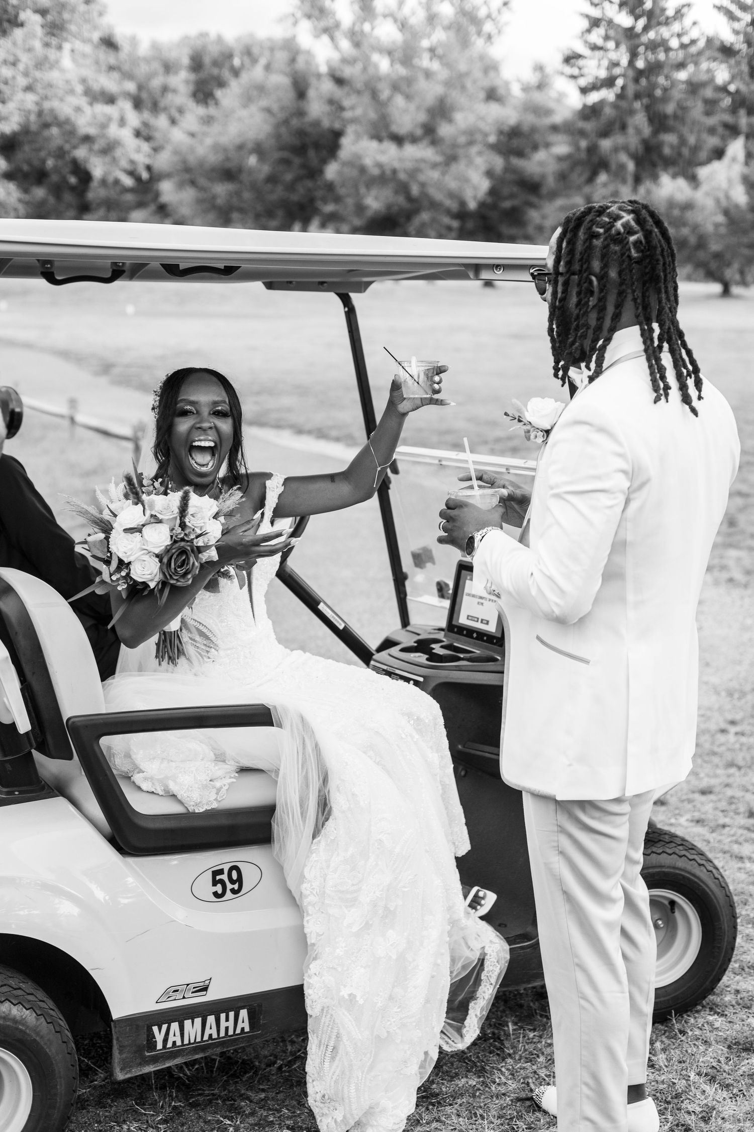 A joyful couple celebrating their wedding day and being escorted on a golf cart.