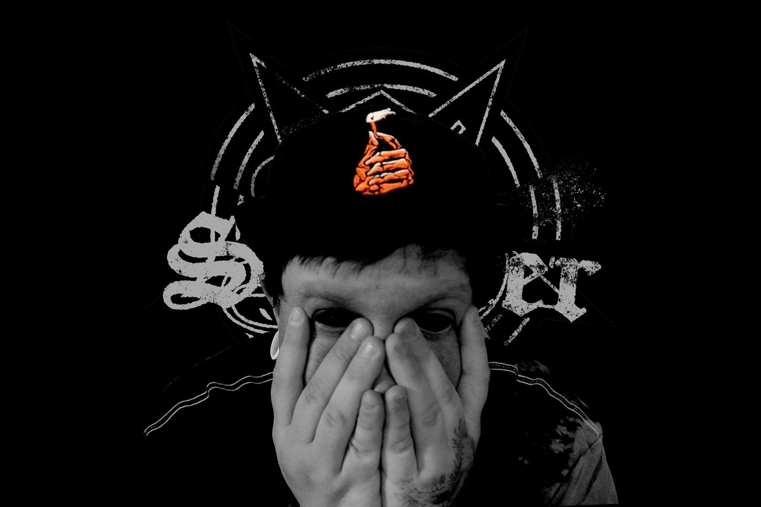 Person wearing cat ear beanie covers face with hands against dark background.