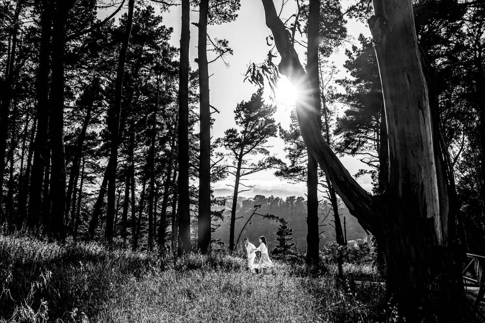 Couple frolicking through Junipero Serra Park