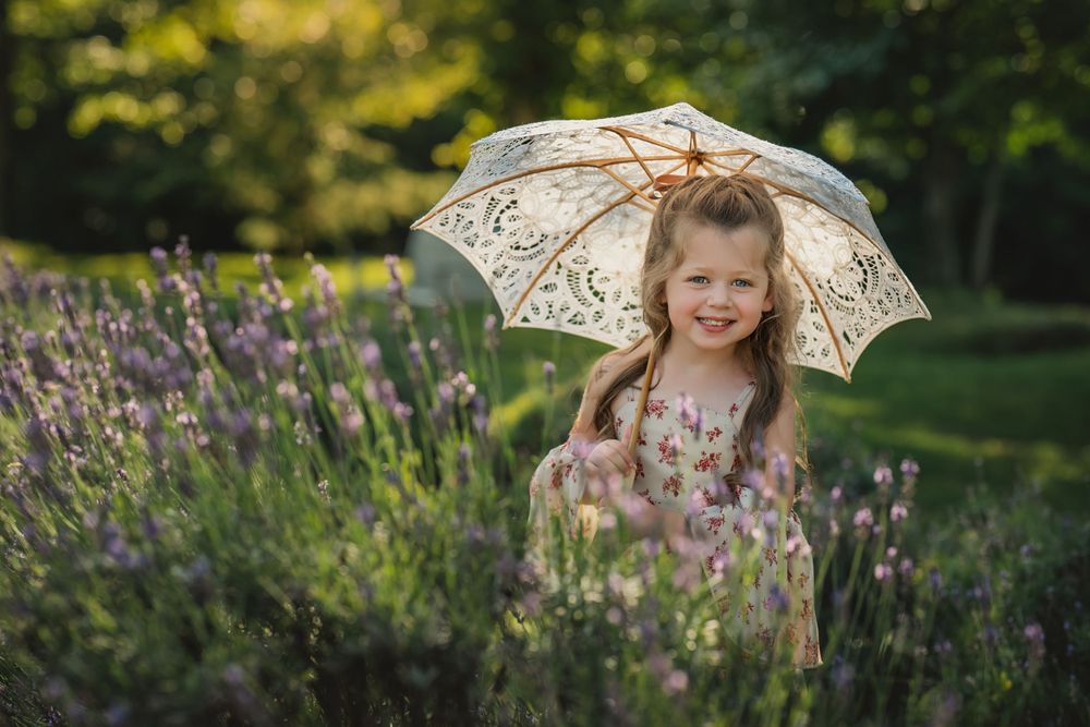4 year old girl with lace parasol in row of lavender