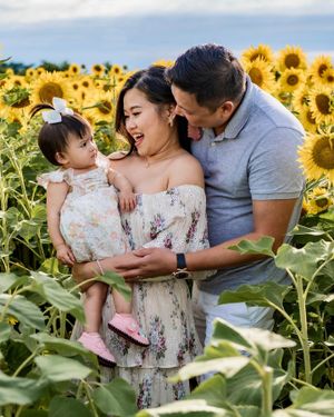 A joyful moment captured amongst vibrant yellow sunflowers in a beautiful field.