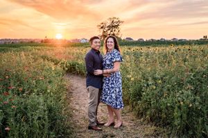 A romantic sunset portrait in a wildflower field with golden light illuminating the scene.