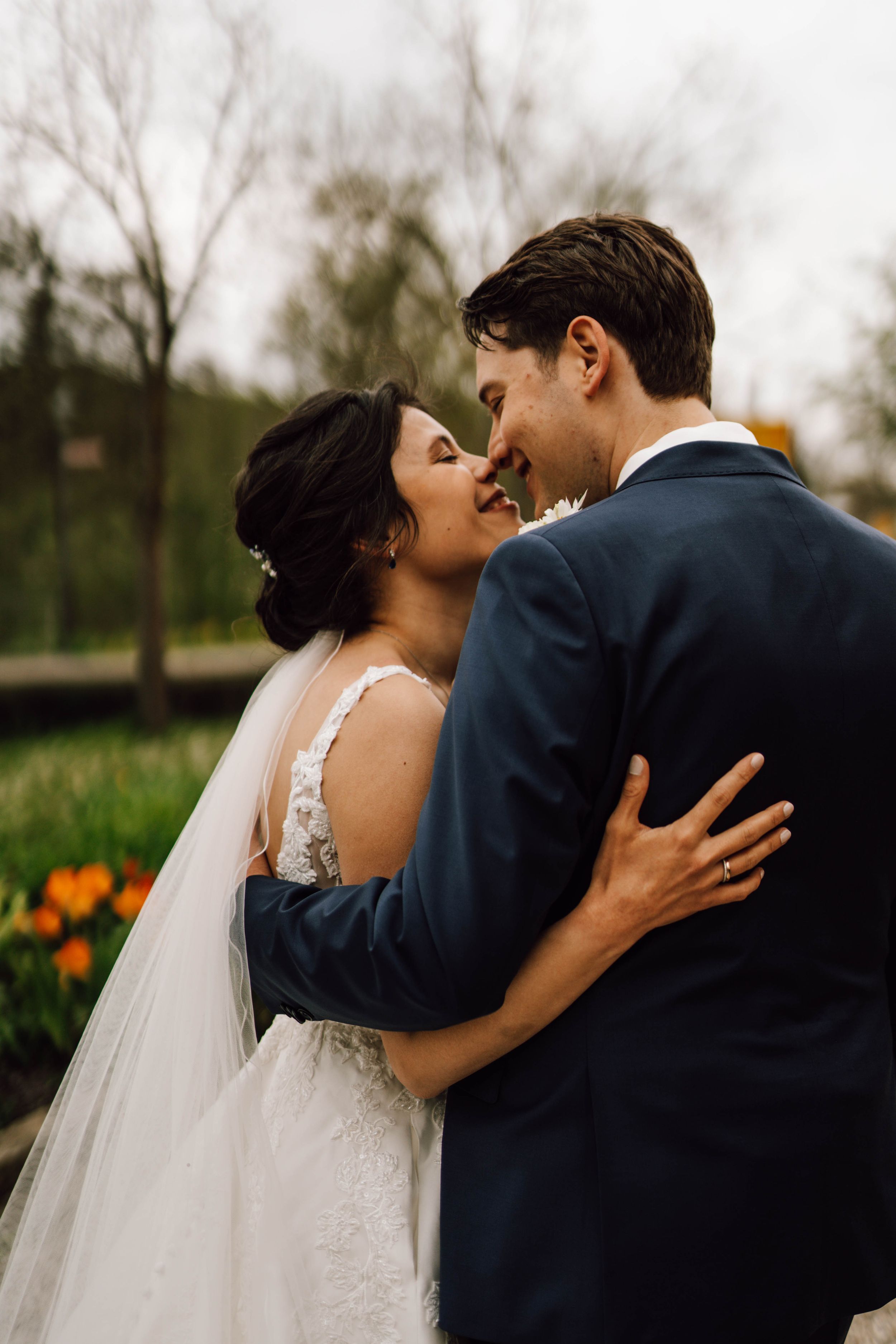 Romantic outdoor wedding portraits with spring flowers in the background.