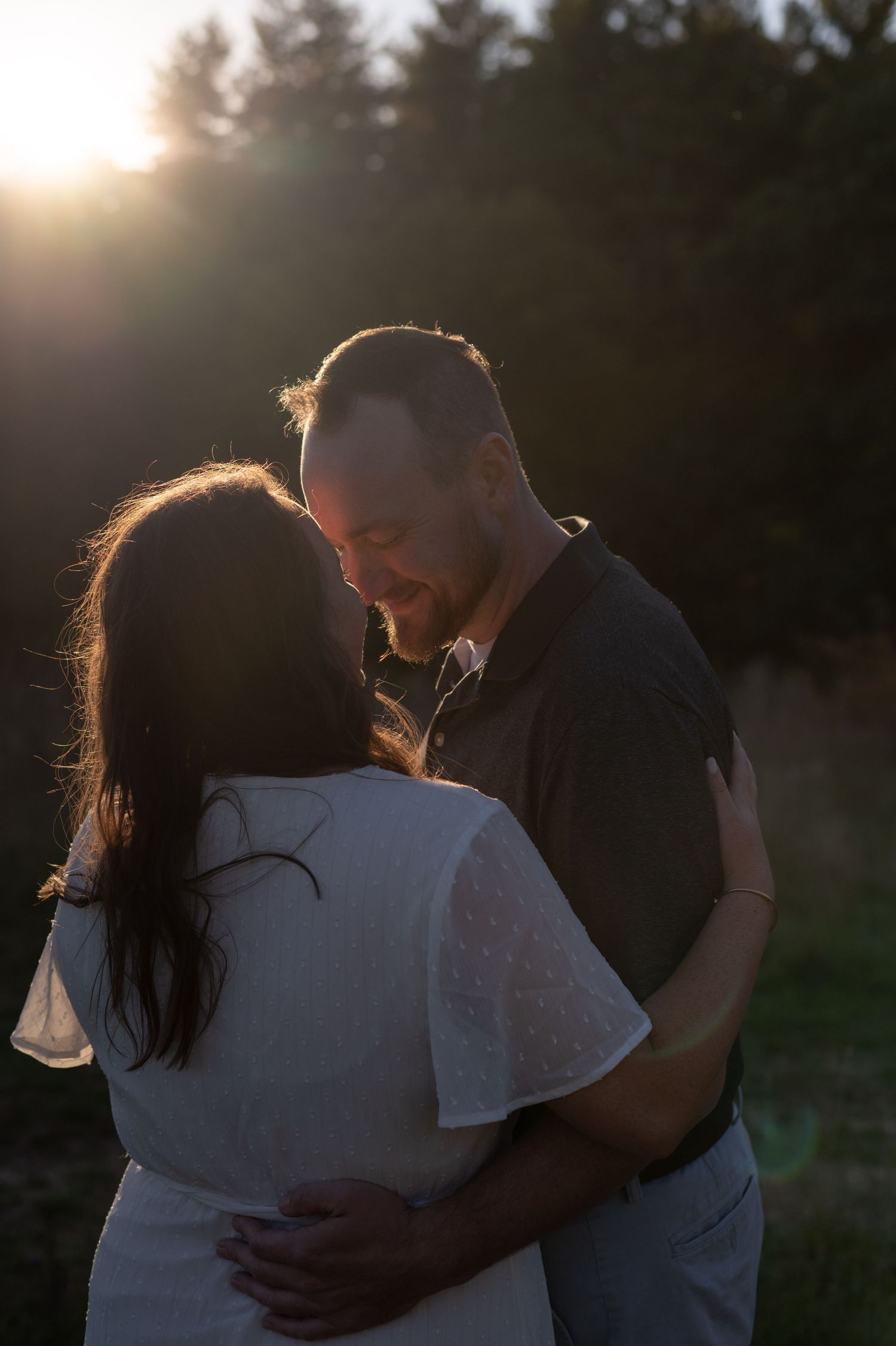 Intimate sunset embrace captured in golden hour lighting.
