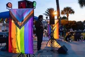 Evening performance setup with colorful pride banners and stage equipment.