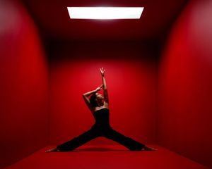 Dramatic dance silhouettes performing splits and jumps against red illuminated backdrop.