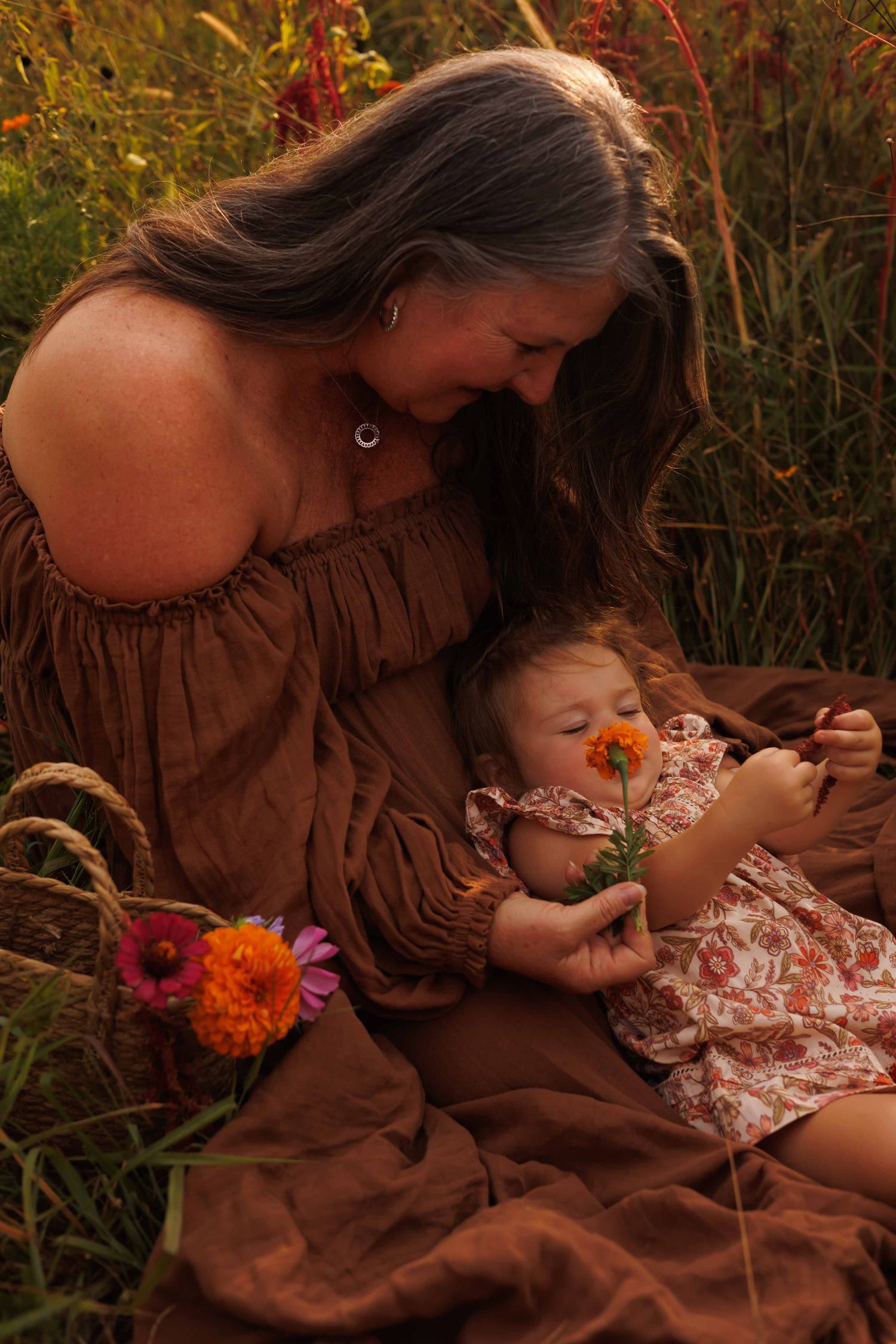Two people share a tender moment among wildflowers at sunset.