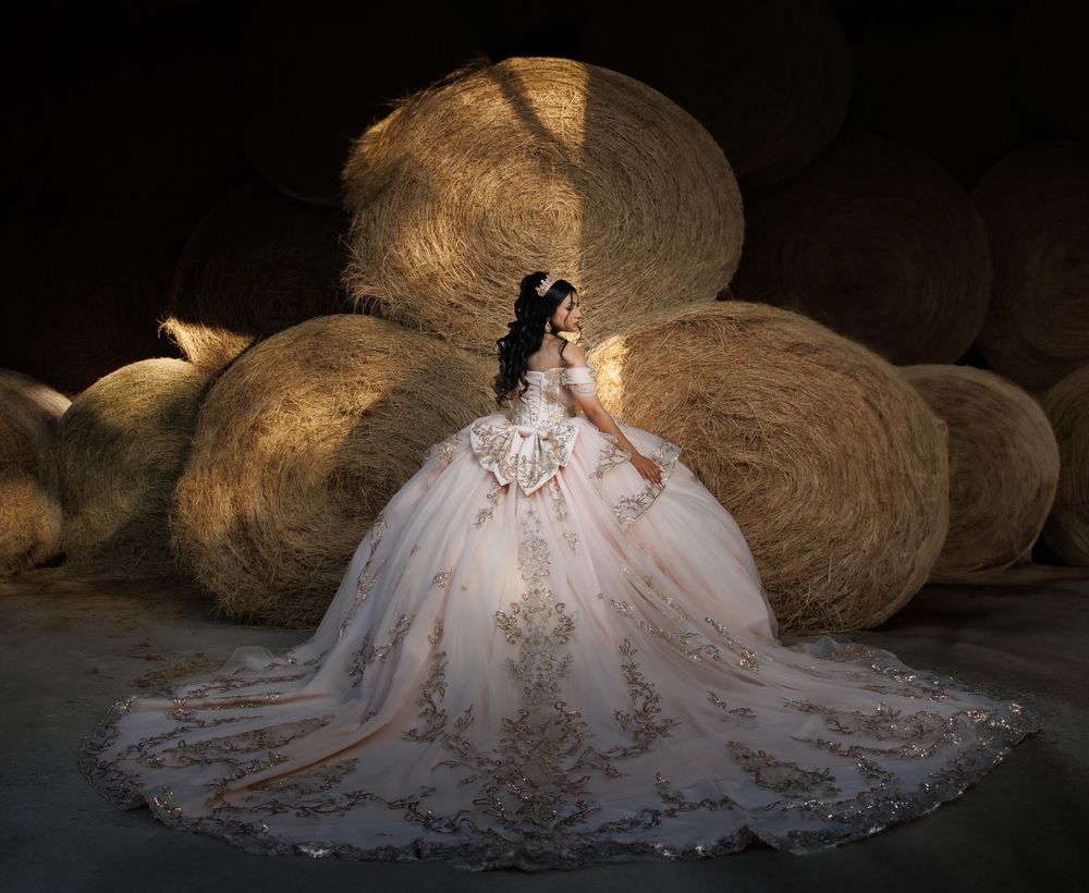 Dramatic evening bridal portraits with ornate wedding dress silhouetted against dark background.