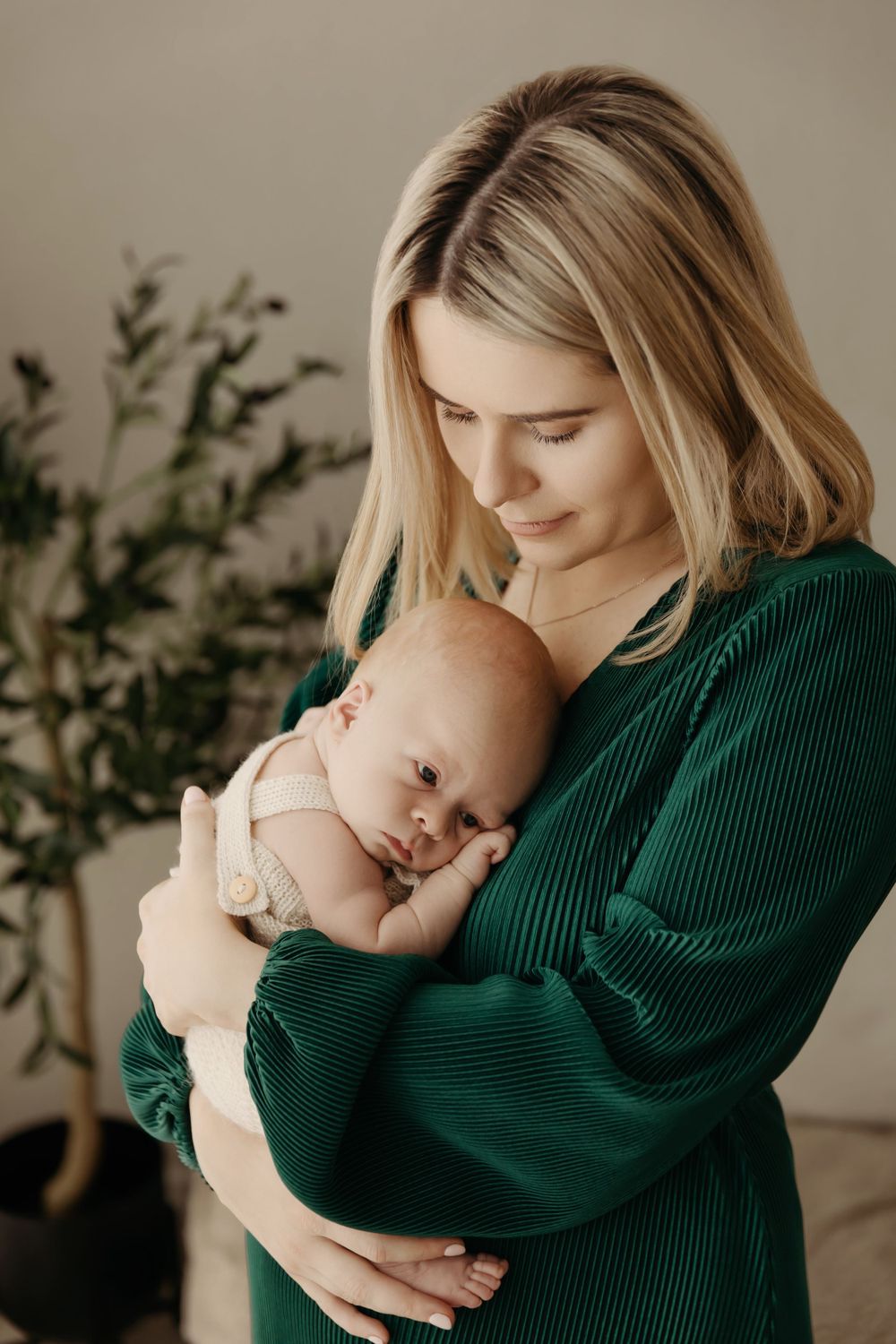 mum in green dress with newborn baby boy