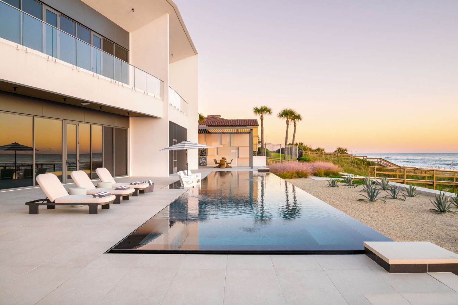 Florida home pool with lounge chairs and ocean in the background