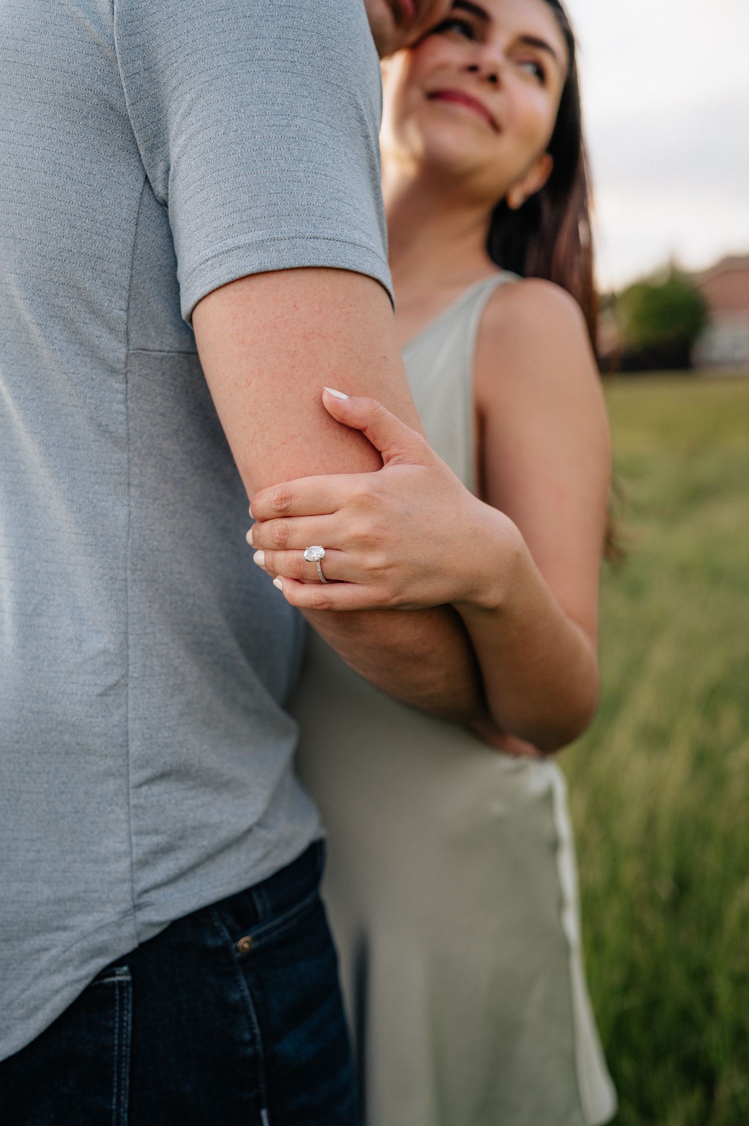 Close-up of gentle embrace with hands and arms in outdoor setting.