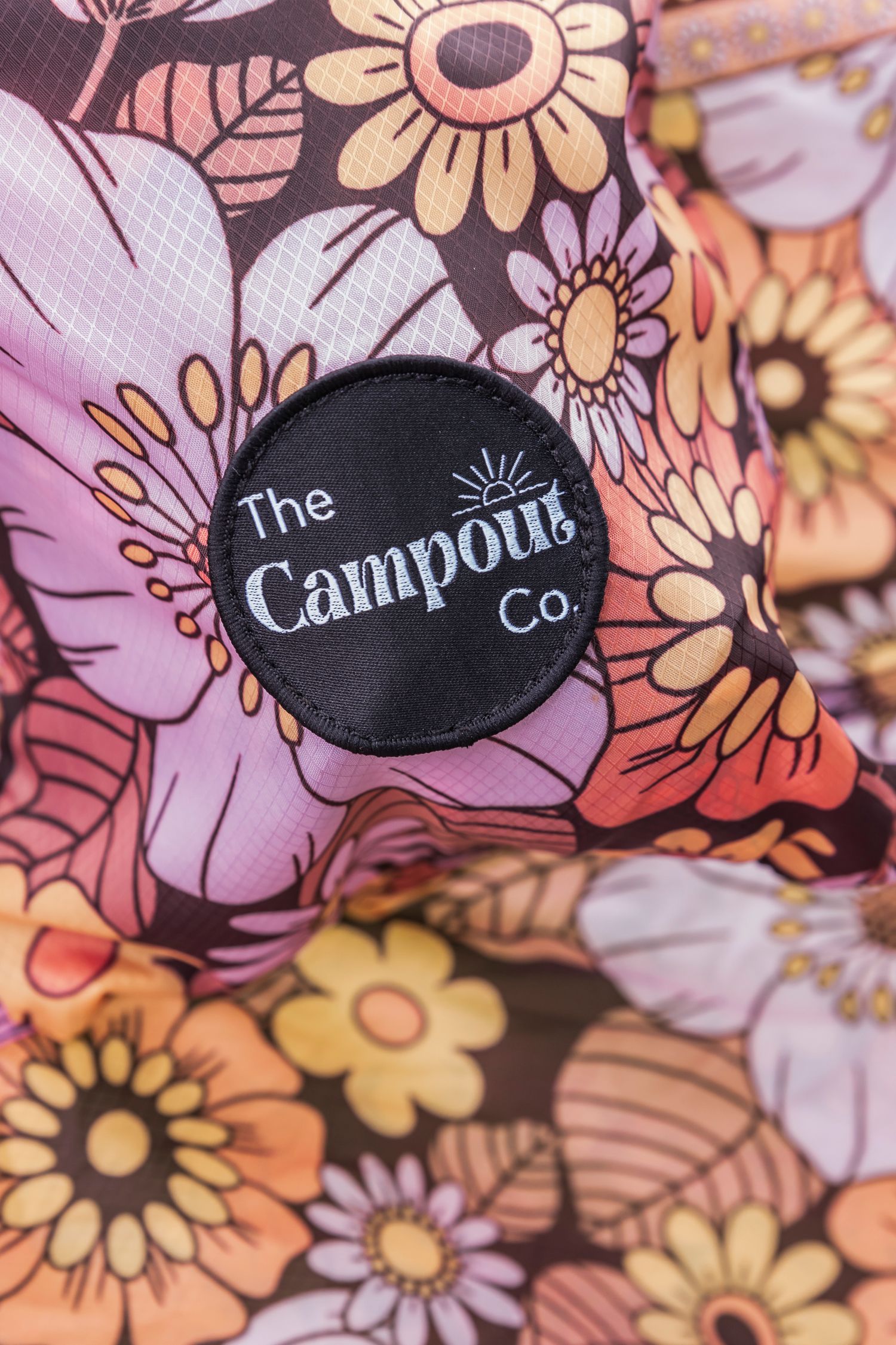 Floral patterned fabric with The Campout Co. logo tag in black.