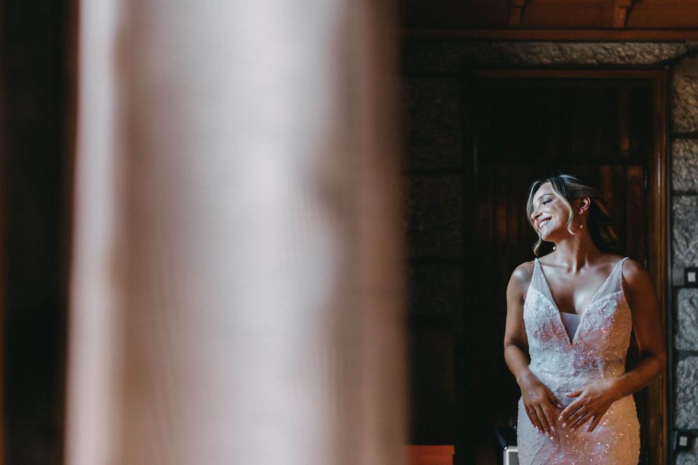 Wedding dress detail shot in a dramatic window light setting.