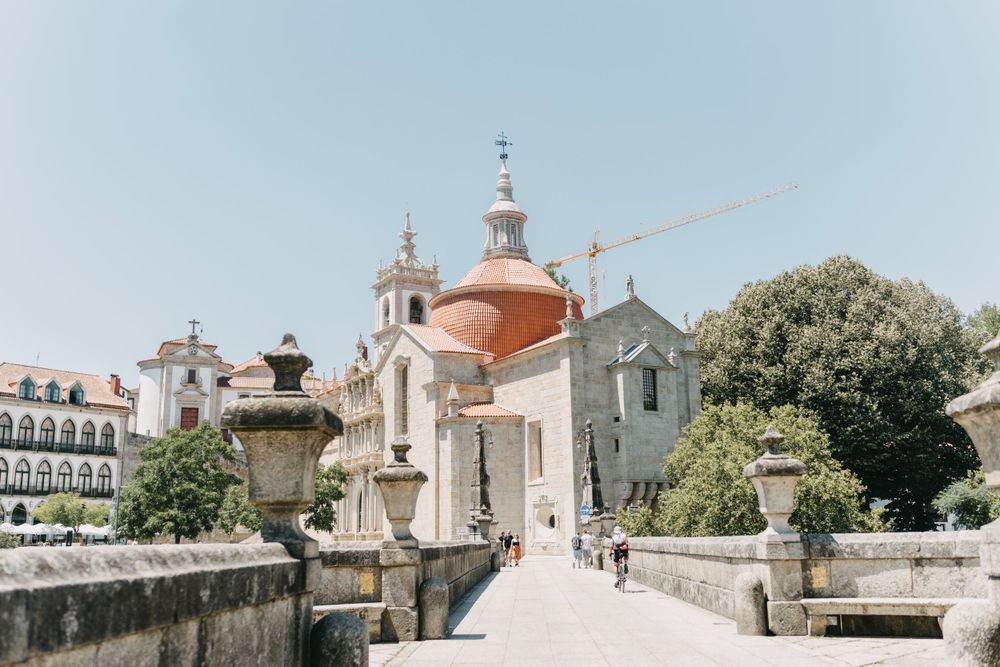 Historic church with dome and stone bridge path leading to its entrance on a sunny day.