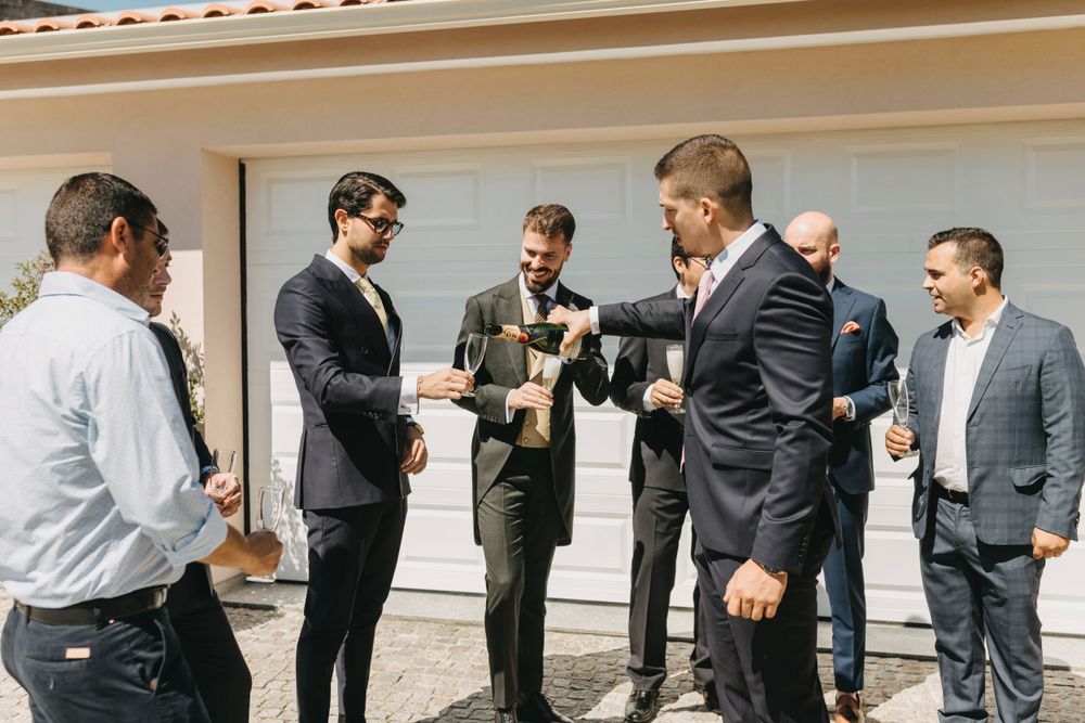 Groomsmen celebrating outdoors in formal attire.