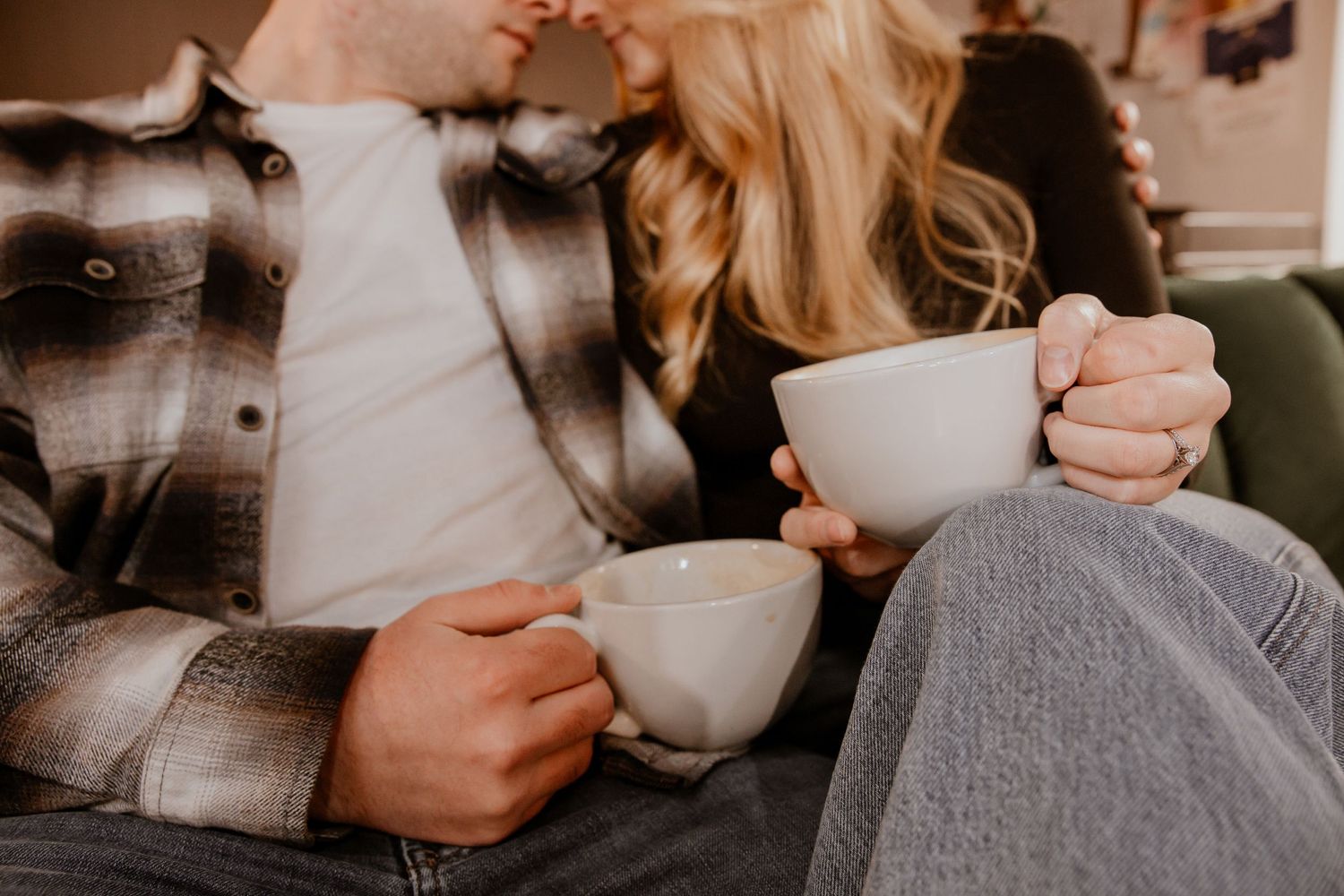Cozy indoor scene with hands holding coffee mugs in warm lighting.