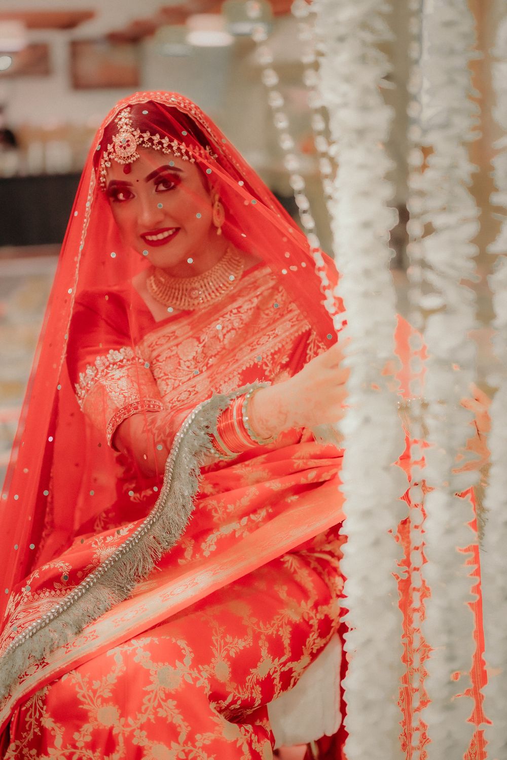 Close-up details of traditional red Indian bridal attire with silver embellishments.