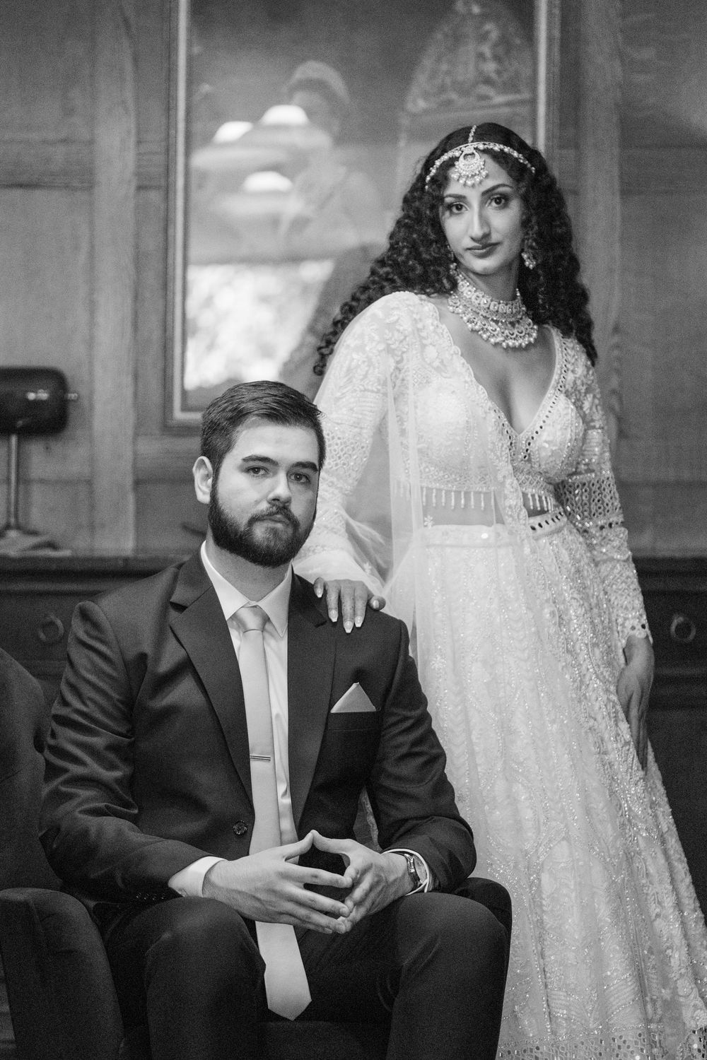 Dramatic black and white portrait of couple in formal wedding attire.