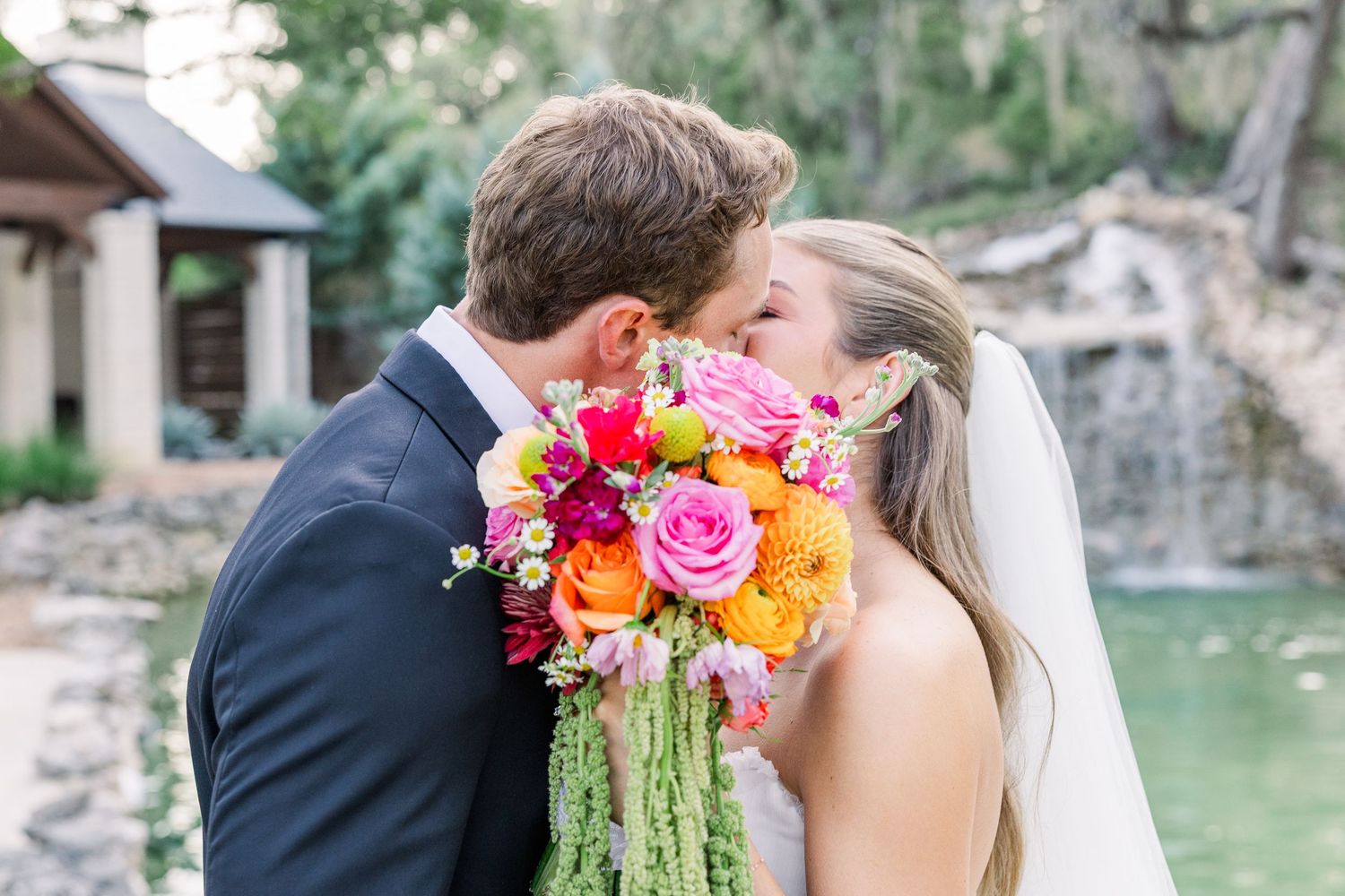 bride and groom newlywed portrait in front of decorative pool boho wedding dress with pearl accents