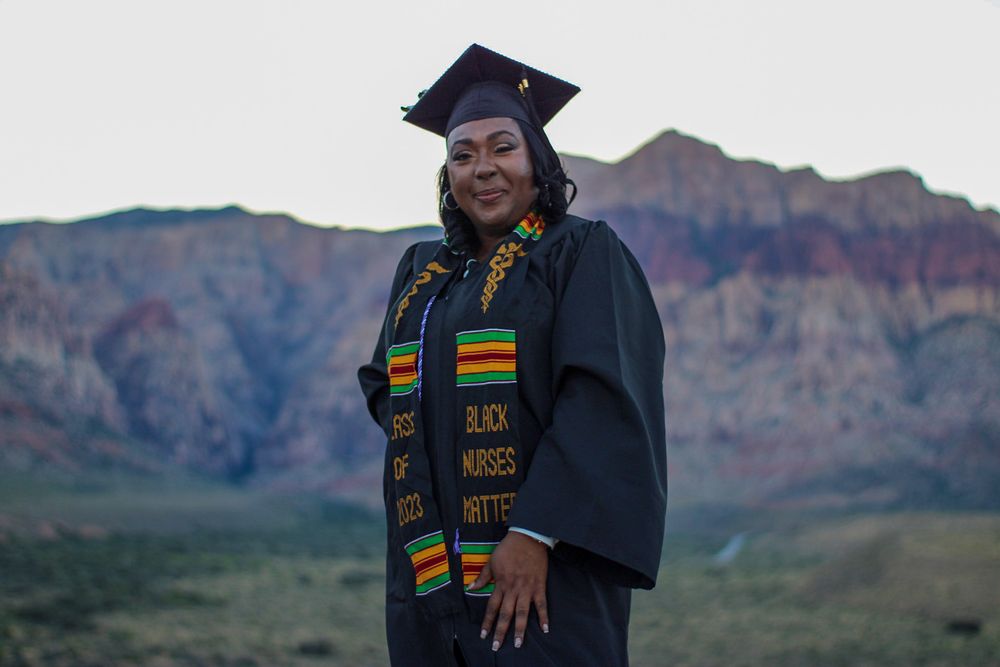 Graduate in cap and gown wearing Black Nurses Matter kente stole at Red Rock Canyon.