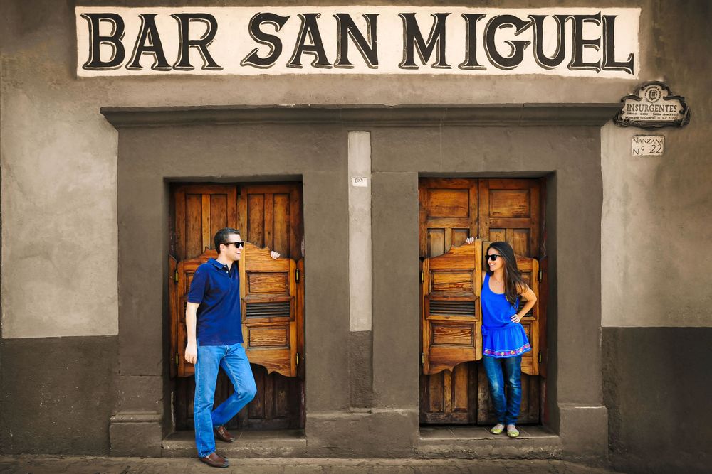 Progressive sequence of couple walking past Bar San Miguel storefront.
