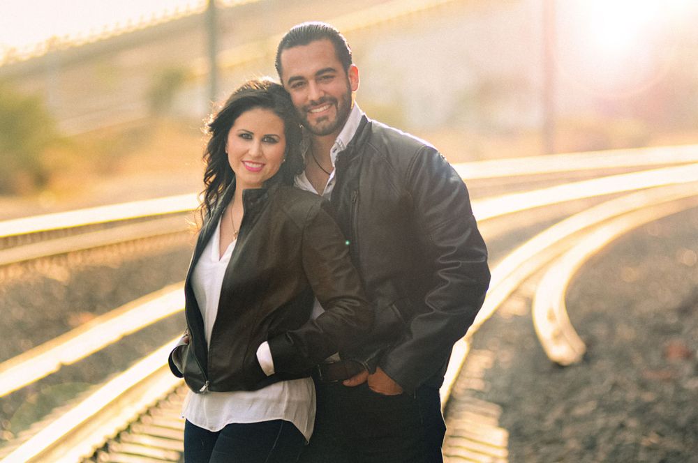 Couple embraces at sunset in a romantic outdoor photoshoot.