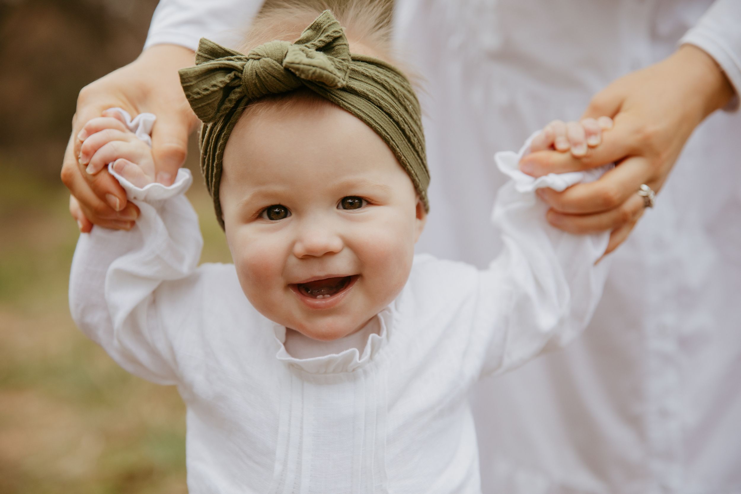toddler holding Mummy's hands laughing
