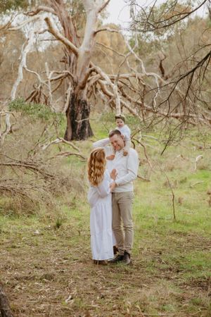 Cuddling family under the trees in Teesdale, Victoria