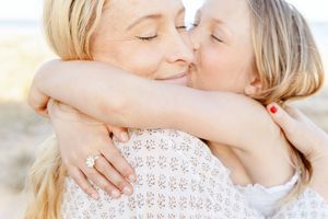 A tender moment between parent and child as they embrace and share a loving kiss.