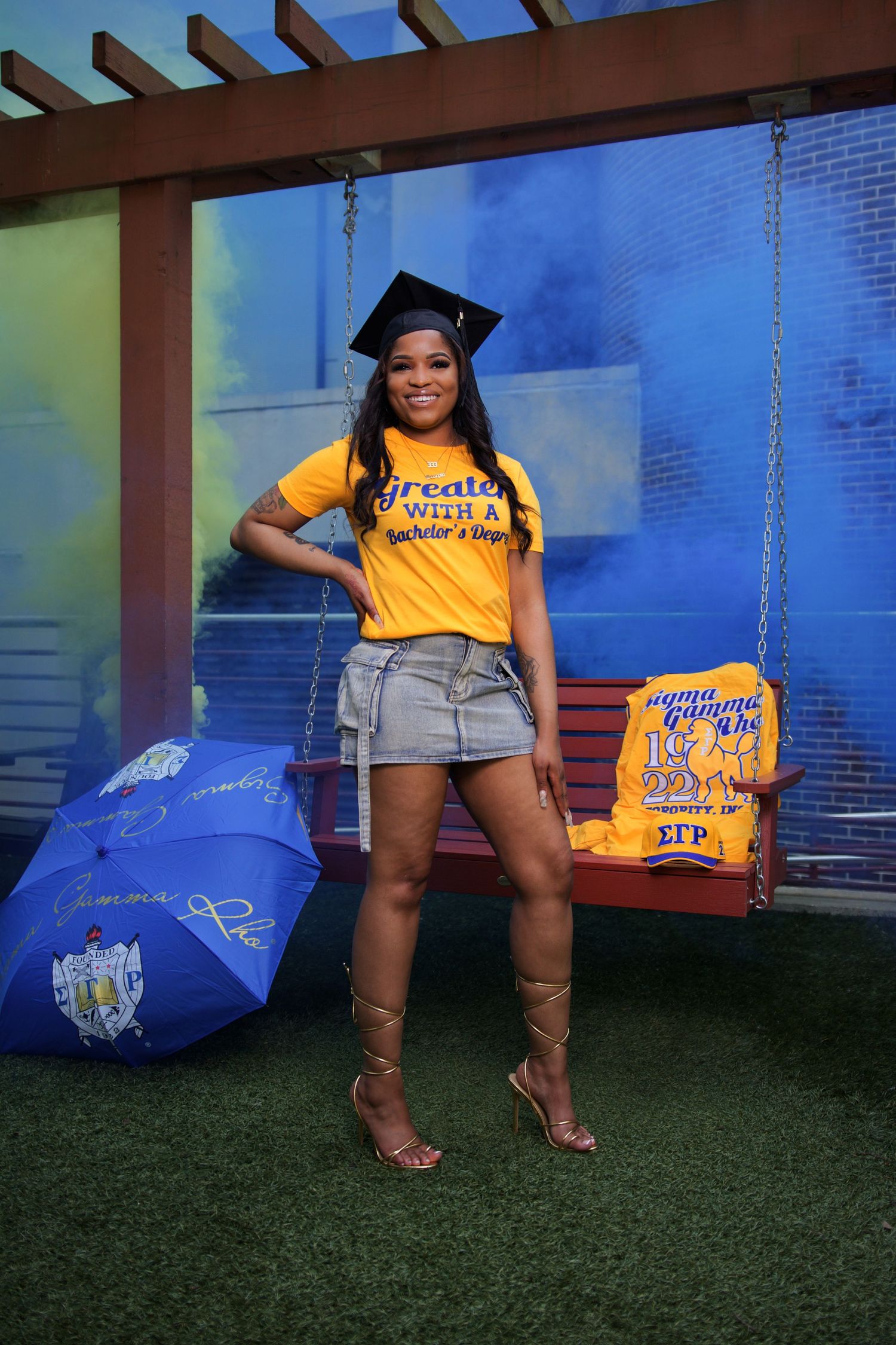 Graduation portrait session at Georgia State University in Atlanta, Georgia with cap and gown with blue and yellow smoke