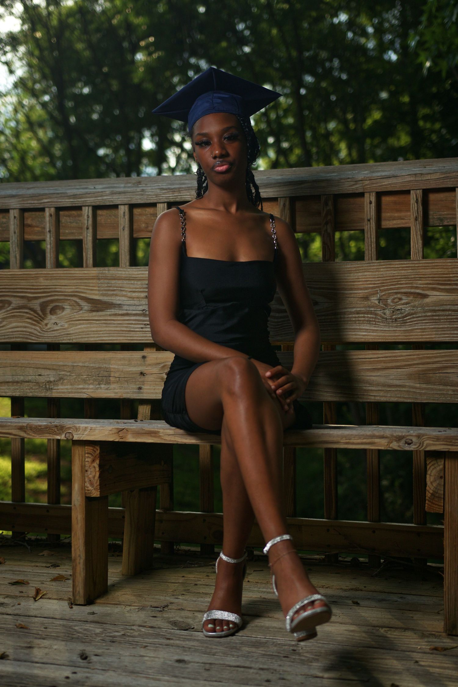 High school graduate in cap and gown posing outdoors at McDonough High School in McDonough, GA