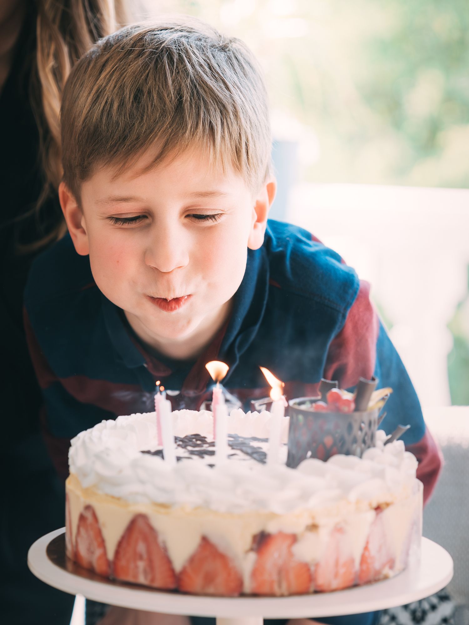 Photographie d'un garçon soufflant ses bougies d'anniversaire