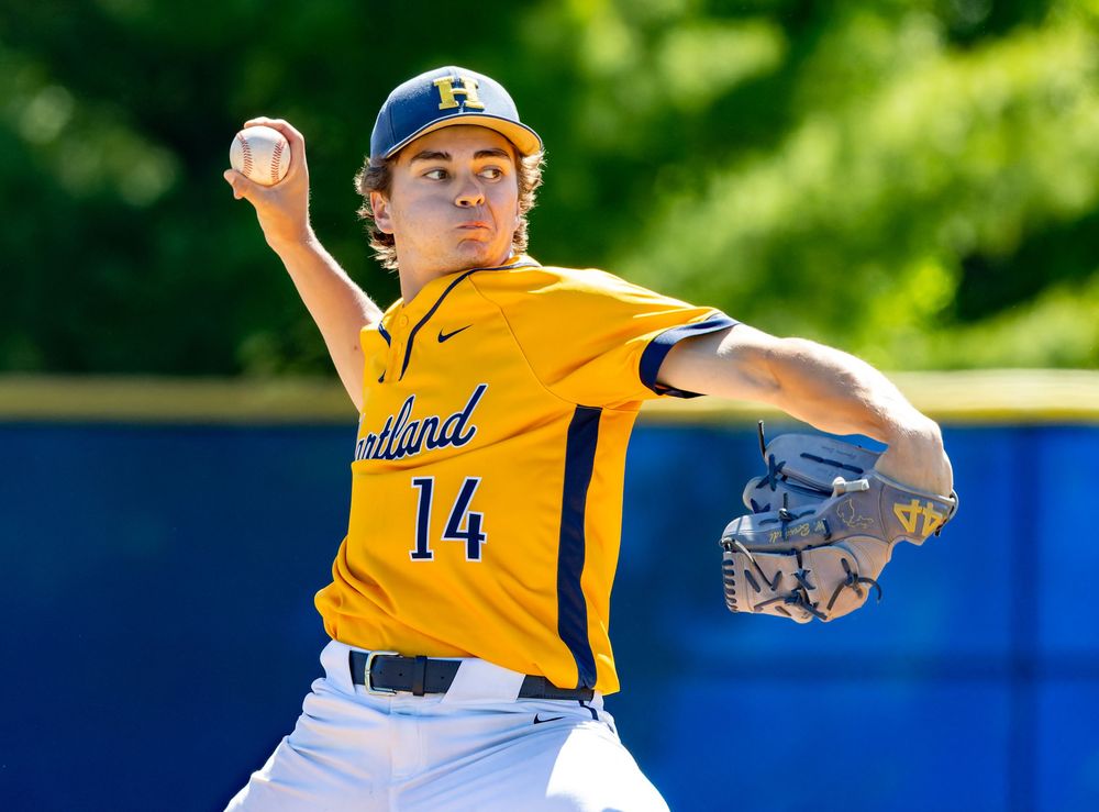Baseball pitcher #14 in yellow Cortland uniform winds up to throw during a sunny outdoor game.