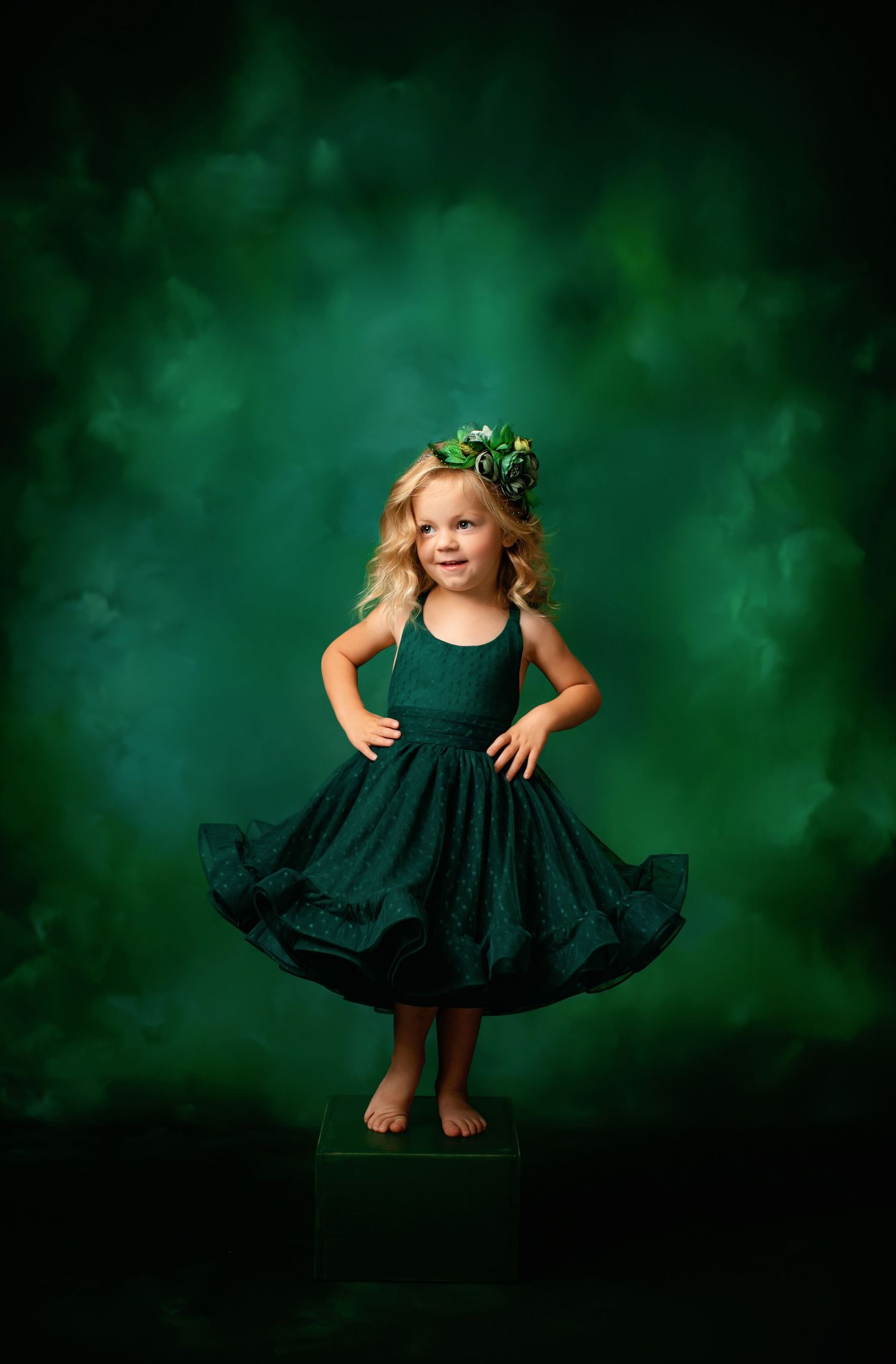 Dark green party dress twirls against mystical emerald smoke background.
