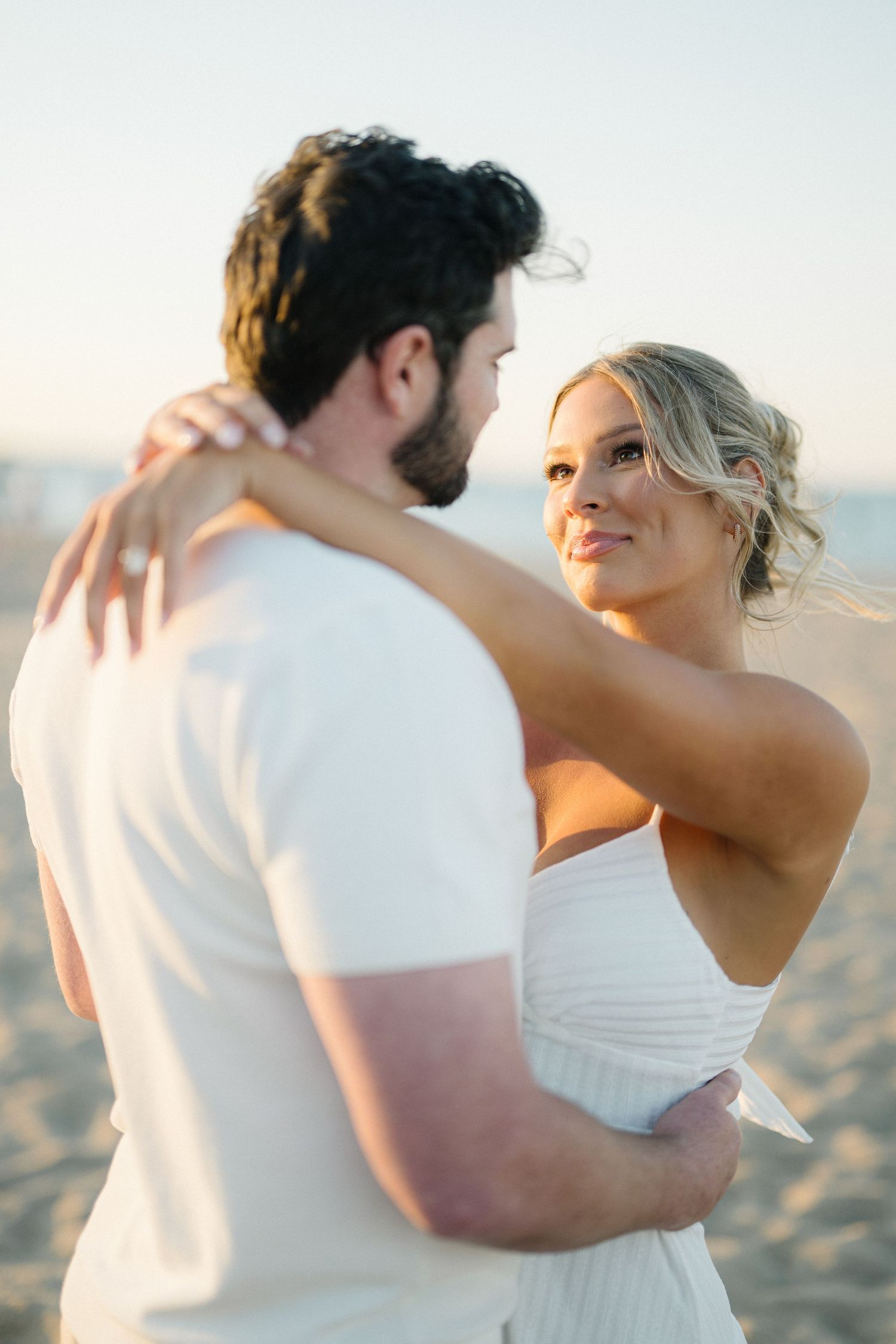A couple in white embraces during golden hour at North Avenue Beach in Chicago.