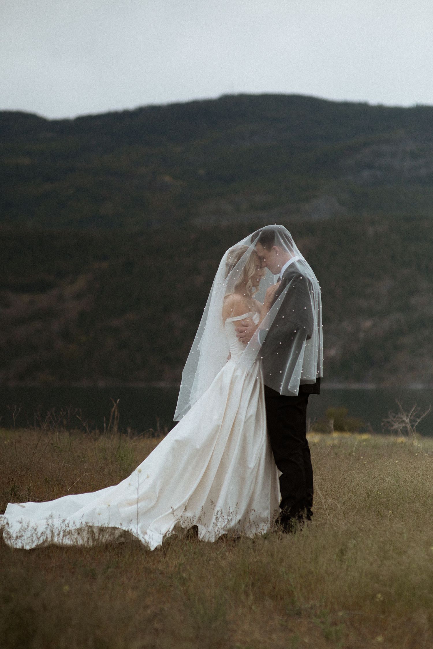 Bride and groom with veil over heads