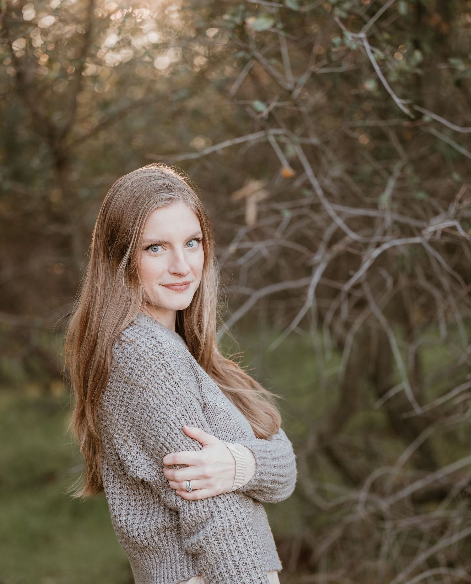 Cozy winter portrait session featuring a chunky knit sweater in a natural outdoor setting.