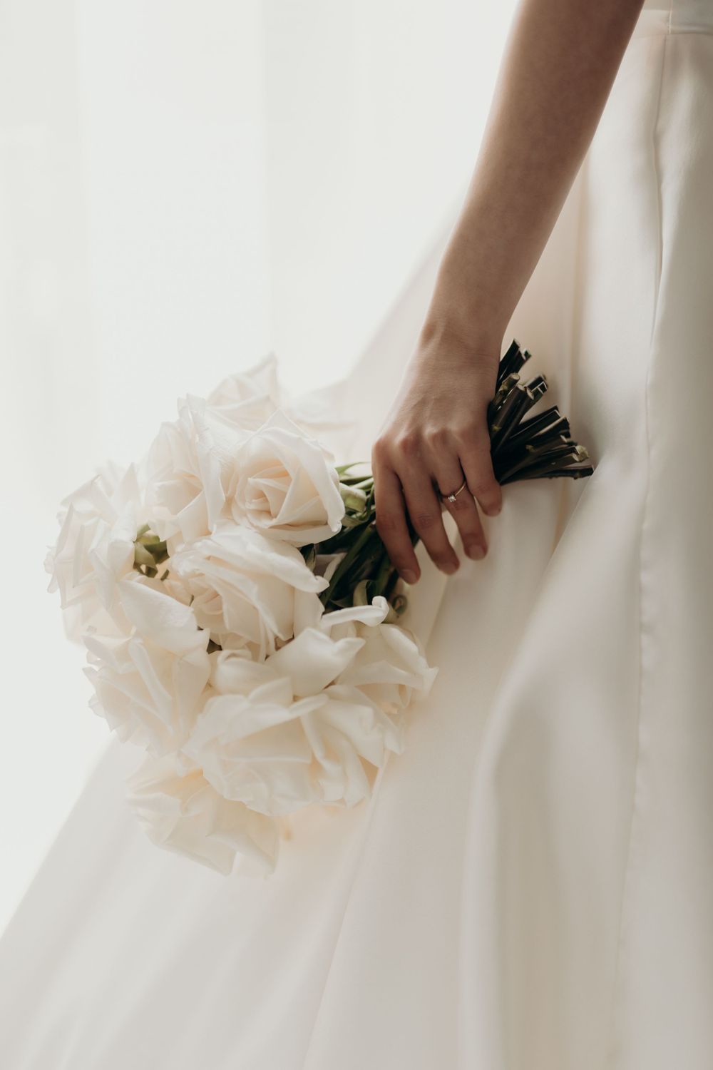 A bouquet of white roses held in a bride's hand