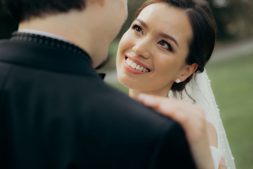 bride is smiling and looking at her groom